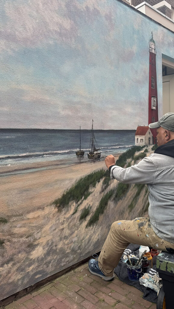 Cor Wakum werkend aan een muurschildering op de Hoge Prins Willemstraat